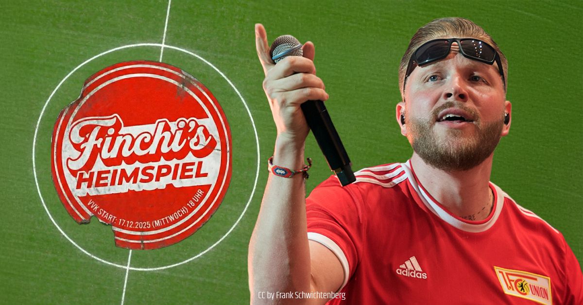Mann mit Mikrofon in rotem Shirt auf einem Fußballfeld-Hintergrund, mit einem Logo "Finchi's Heimspiel".